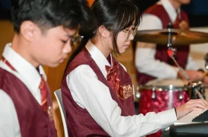 Student playing piano wearing Global Ark International School uniform